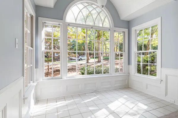 Bright room with white wainscoting, window casing and an arched window